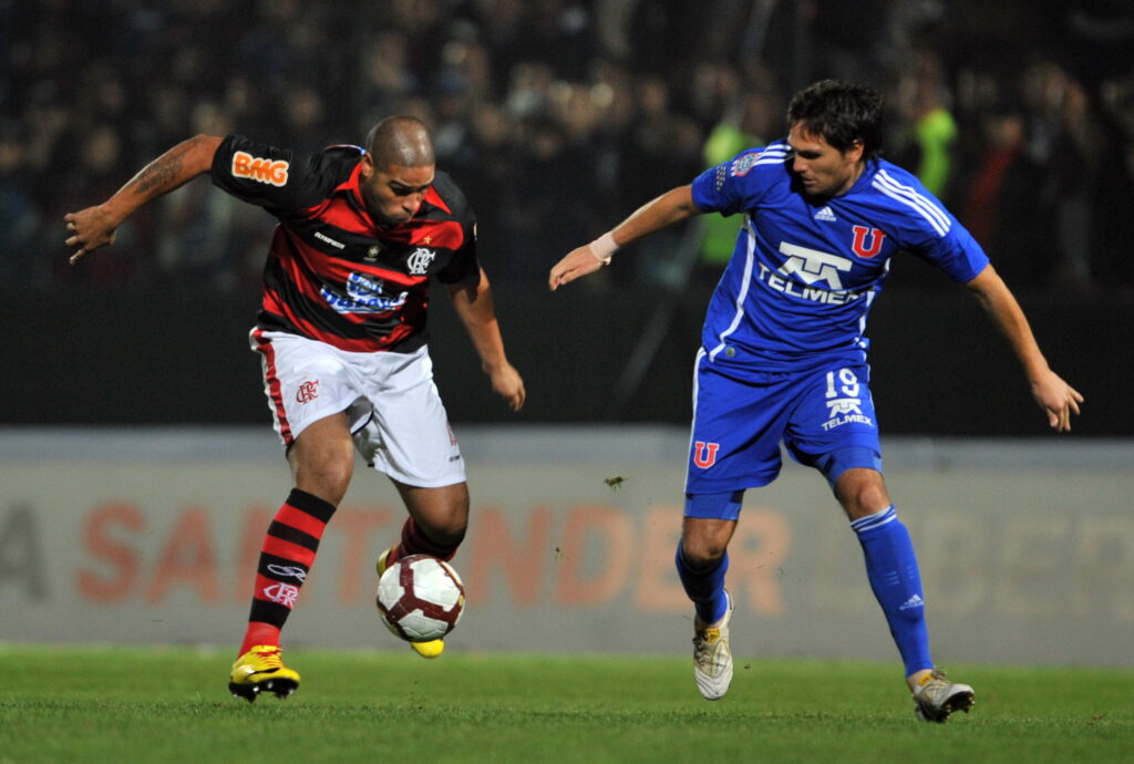 Adriano (L), do Flamengo, disputa a bola com Rafael Olarra (R), da Universidade do Chile, durante a partida de futebol da Copa Libertadores no estádio Santa Laura, em Santiago, em 20 de maio de 2010.