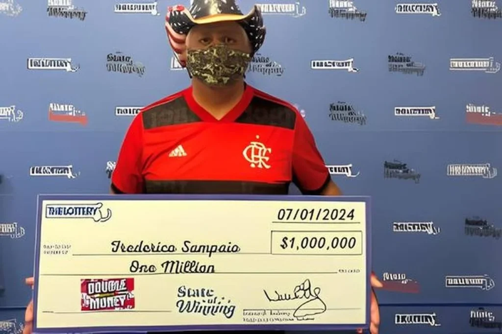 Frederico Sampaio com camisa do Flamengo enquanto recebe prêmio da loteria