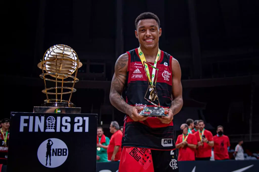 Yago Mateus ao com troféu de MVP das finais e taça do NBB ao lado;