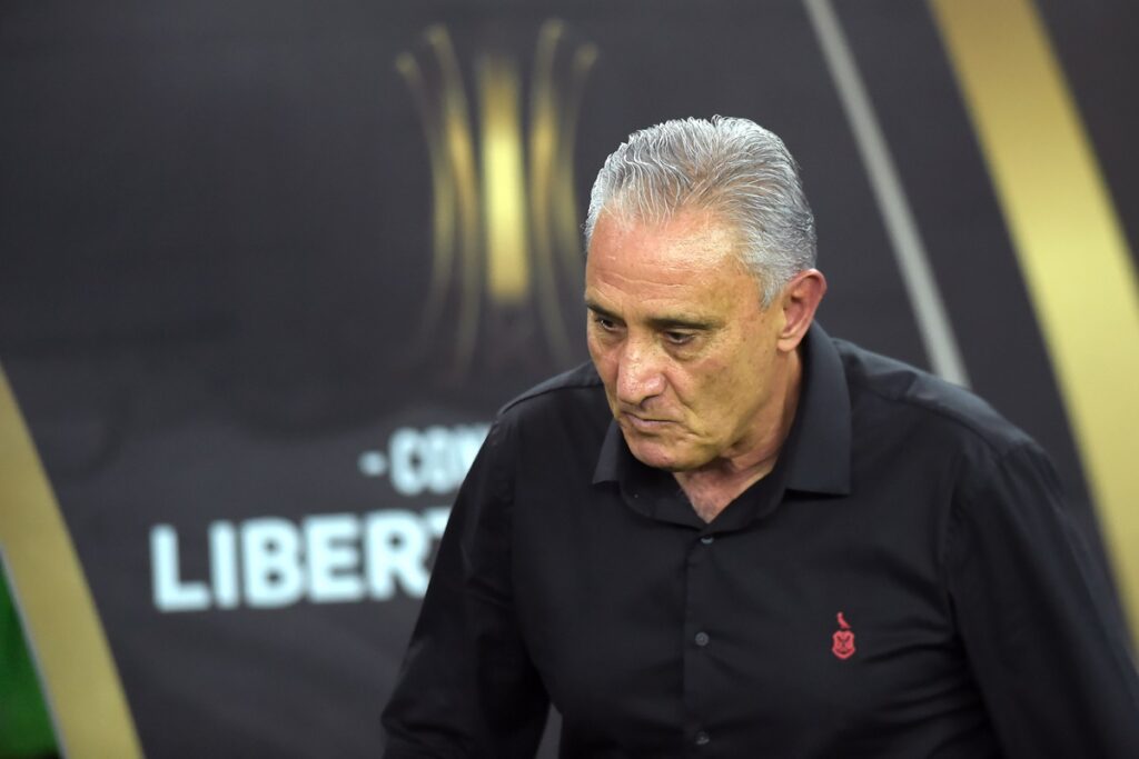 Tite cabisbaixo e ao fundo um banner da Libertadores em Flamengo x Peñarol