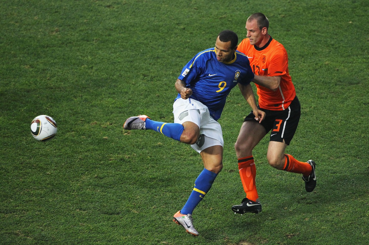 Luis Fabiano, do Brasil, tenta controlar a bola sob pressão de André Ooijer, da Holanda, durante a partida das quartas de final da Copa do Mundo da FIFA África do Sul de 2010 entre Holanda e Brasil no Estádio Nelson Mandela Bay em 2 de julho de 2010