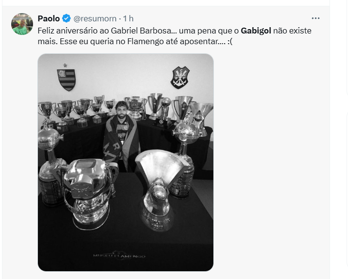 Gabigol posa envolto na bandeira do Flamengo e cercado por taças conquistadas pelo clube