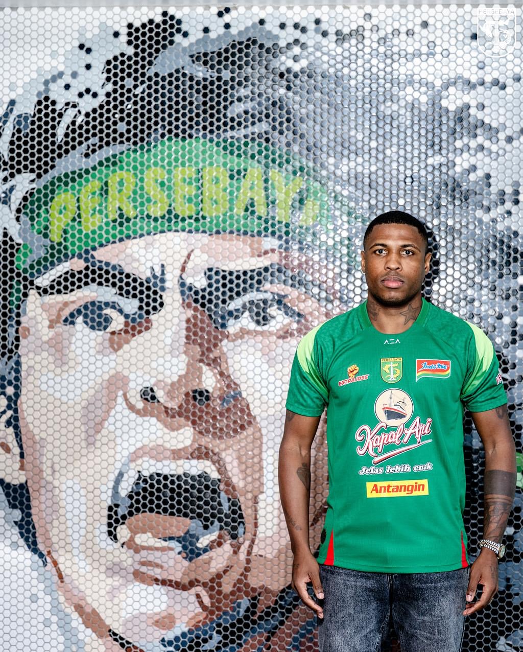 Foto de Diego Mauricio como novo reforço do Persebaya, da Indoneisa. O jogador veste a camisa verde do clube.