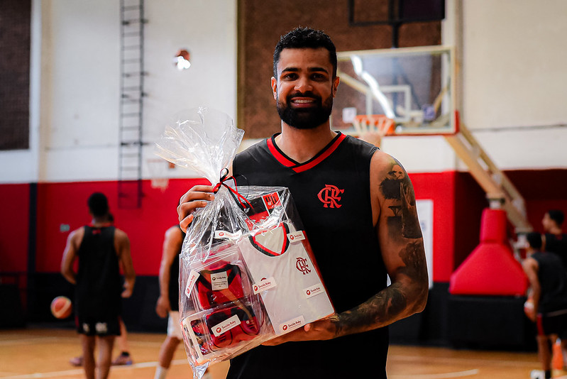 A espera de um filho, Wesley Castro segura kit com roupas do Flamengo para bebês que recebeu no primeiro dia da pré-temporada do Flamengo