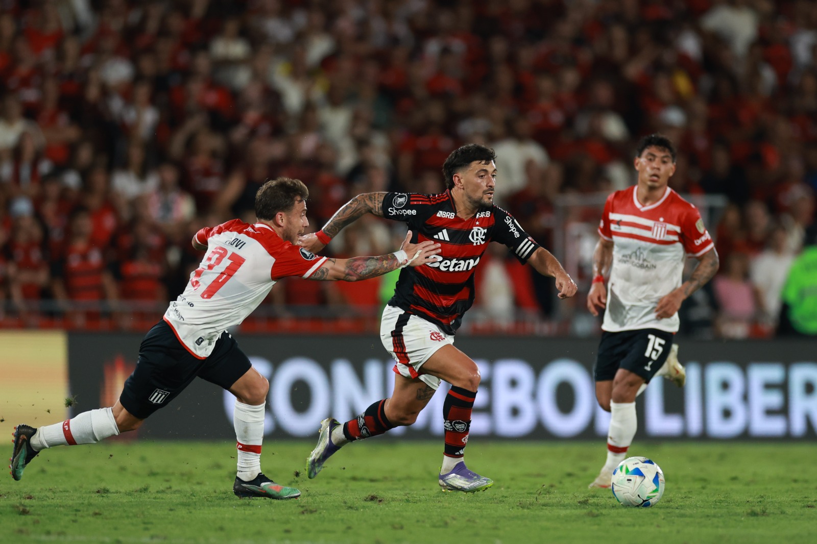 Giorgian de Arrascaeta, do Flamengo, é desafiado por Ezequiel Piovi, do Estudiantes, durante a partida de ida das quartas de final da Copa CONMEBOL Libertadores 2025 entre Flamengo e Estudiantes, no Estádio do Maracanã, em 18 de setembro de 2025, no Rio d