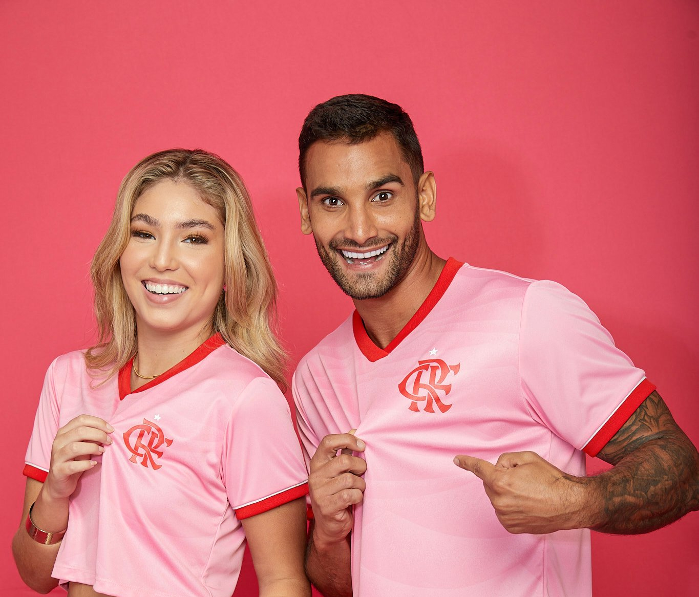Um homem e uma mulher vestindo a camisa rosa do Flamengo, versão de 2023